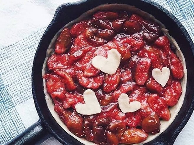 A photo of an unbaked strawberry pie in a small cast iron skillet.