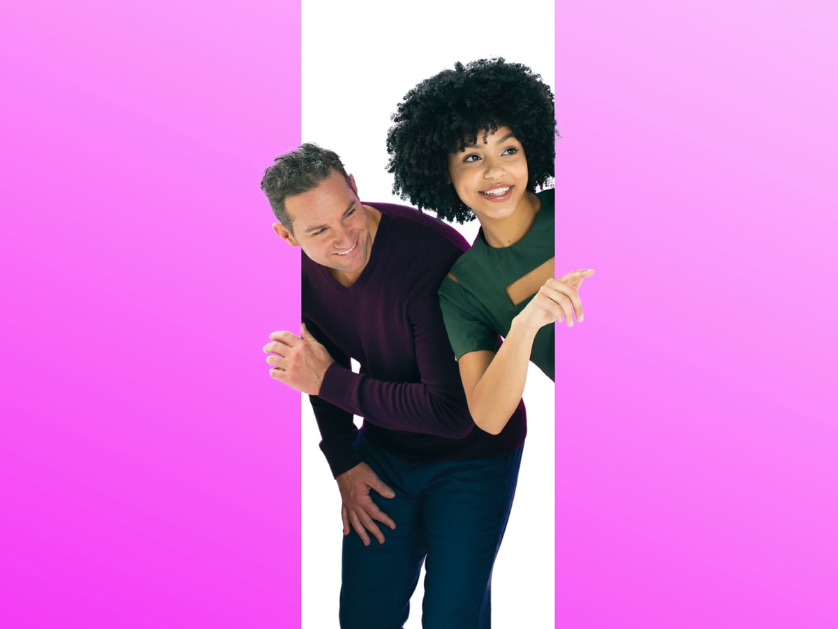 Image of two people peeking through a doorway on a large colorful wall. Image of two people peeking through a doorway on a large colorful wall.